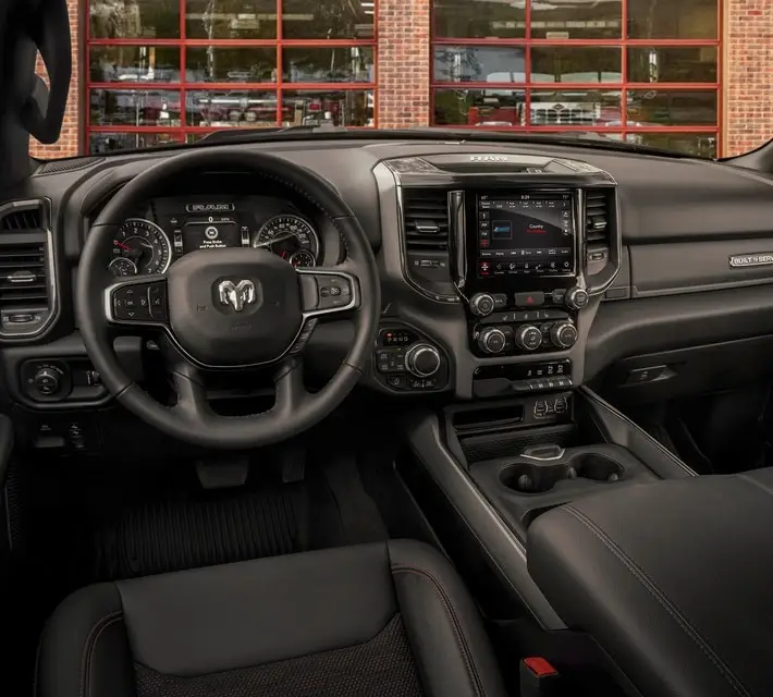 Ram 1500 pickup truck interior showing black leather dashboard and touchscreen infotainment system