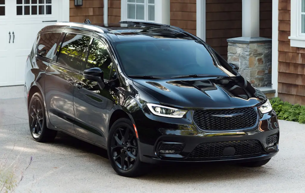 Black Chrysler Pacifica minivan with S-Appearance package parked in driveway outside shingled home