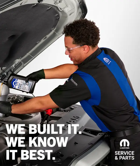 Mopar certified technician adding oil to vehicle engine with "We Built It, We Know It Best" service tagline