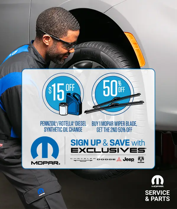 Mopar service technician inspecting tire with $15 off oil change and 50% off wiper blade offer